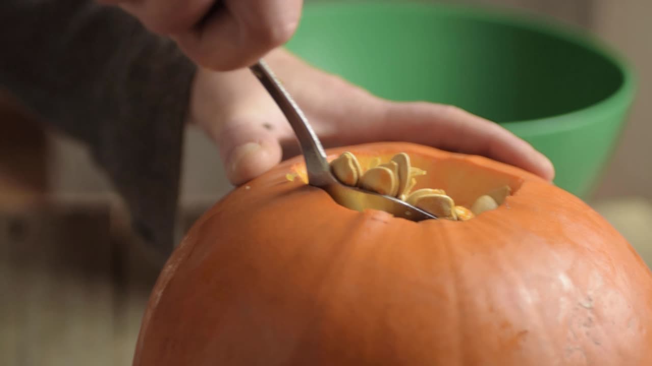 숟가락으로 익은 신선한 호박에서 호박씨를 제거