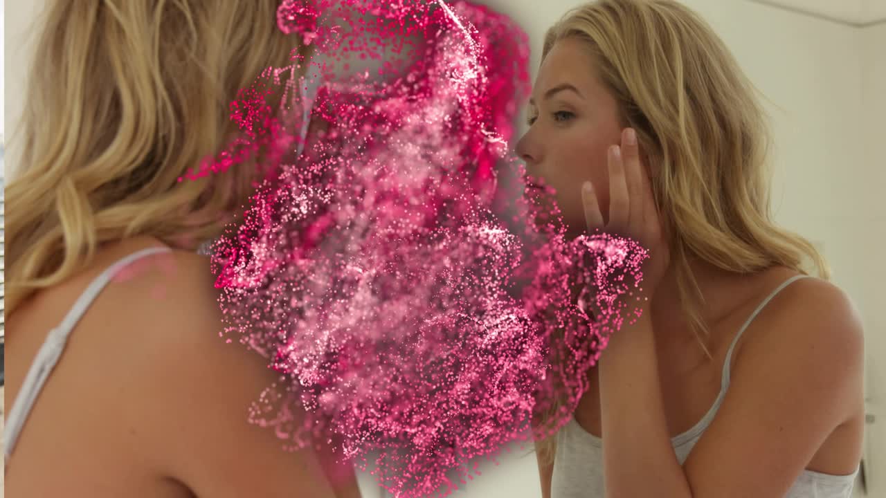 Woman applying skincare inspecting face at sink as pink cloud expanding across mirror hiding view