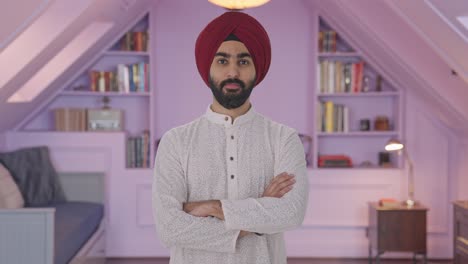 hombre indio sikh confiado de pie con las manos cruzadas