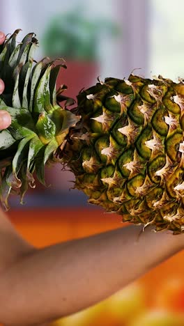 two hands exchanging a pineapple in kitchen