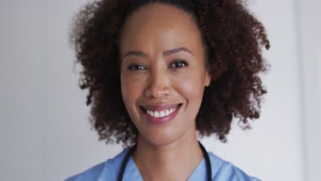 Portrait-of-mixed-race-female-doctor-looking-at-camera-and-smiling