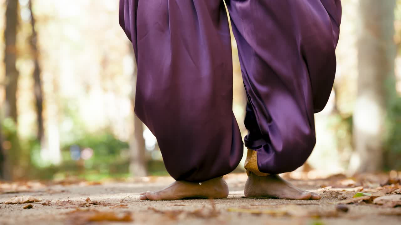 Barefoot walk in purple pants through autumn leaves