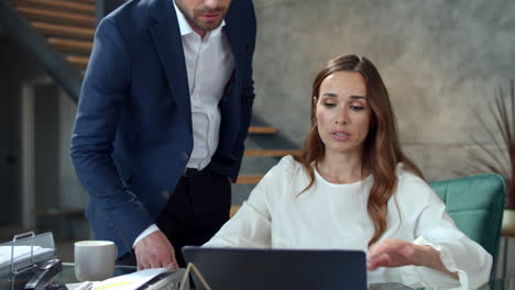 Office-coworkers-discussing-business-in-office.-Man-correcting-papers.