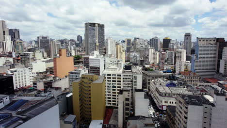Aerial-view-rising-over-high-rise-in-downtown-Sao-Paulo,-sunny-day-in-Brazil