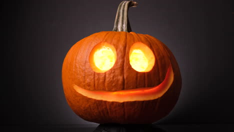 A-Glowing-Pumpkin-With-A-Nice-Smile-Spinning-in-The-Dark,-Jack-O-Lanterns