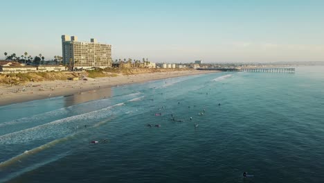 fantástica vista de pájaro de la playa del pacífico y el muelle de cristal de san diego - toma de drones de 4k - surf mientras se pone el sol