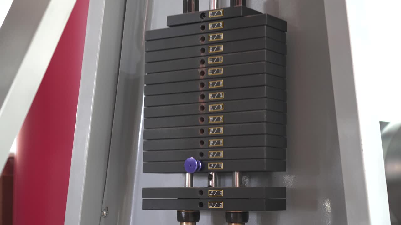 Fitness Gym weights on a machine getting lifted by someone excersizing close up.