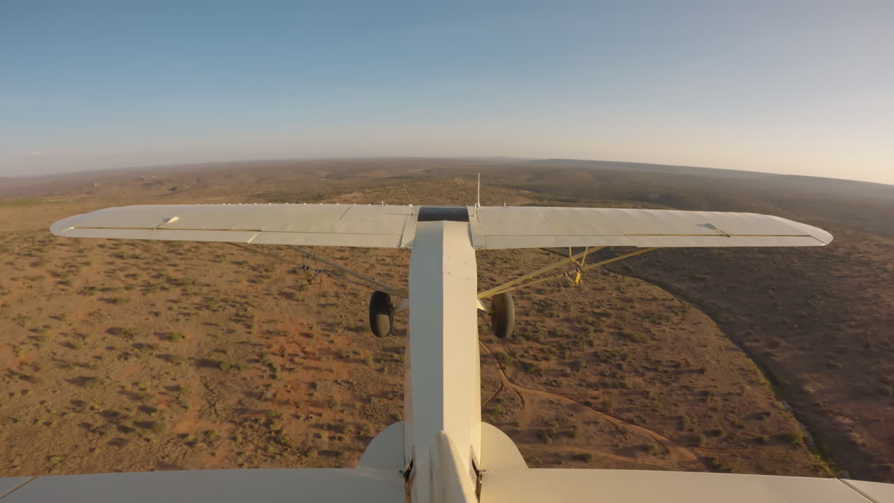 Aereo da bushcraft che sorvola un crinale fluviale nella savana.