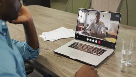 African-american-man-using-laptop-for-video-call,-with-business-colleague-on-screen