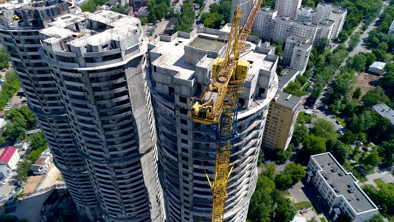 vista de vuelo de pájaro en bloques de torres sin terminar, edificios de apartamentos debajo y carreteras. 4k.