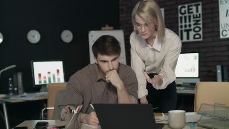 Woman-business-boss-criticizing-young-specialist-work-in-dark-office.-Bad-work