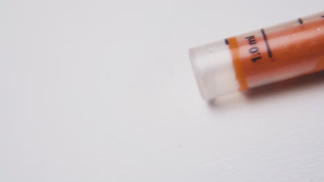 syringe with orange element and scale on white background