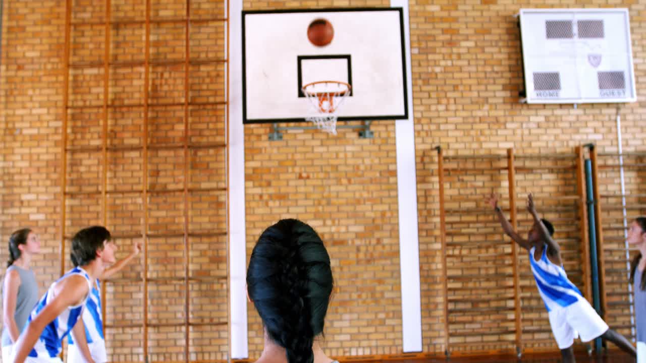 estudiantes de escuela jugando al baloncesto en la cancha de baloncesto