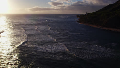 Imágenes-De-Drones-De-Las-Olas-Del-Océano-Pacífico-Se-Mueven-Hacia-La-Costa-De-La-Isla-De-Oahu,-Hawaii,-Cerca-De-Honolulu,-Mientras-El-Sol-Se-Refleja-En-El-Agua.