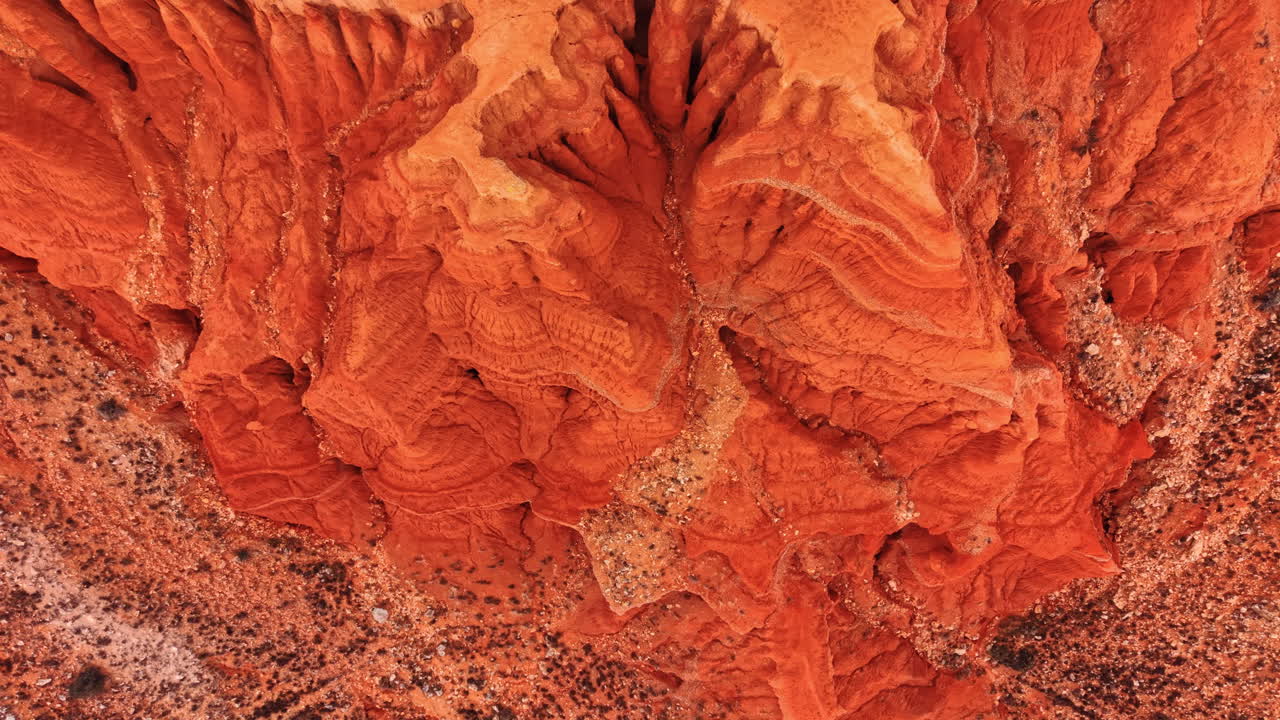 Vista aerea astratta di modelli di erosione del terreno argilloso rosso. Scatto dall'alto di texture naturali e profondi canali di erosione in terra rossa e formazioni rocciose.