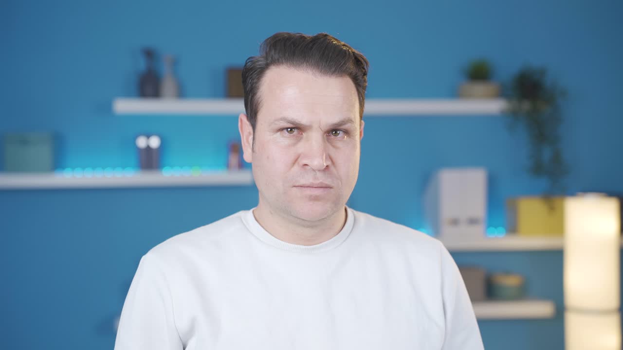 진지하고 집중적인 남자가 카메라를 쳐다보고 있습니다.