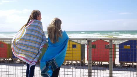 Siblings-standing-with-towels-near-beach-4k