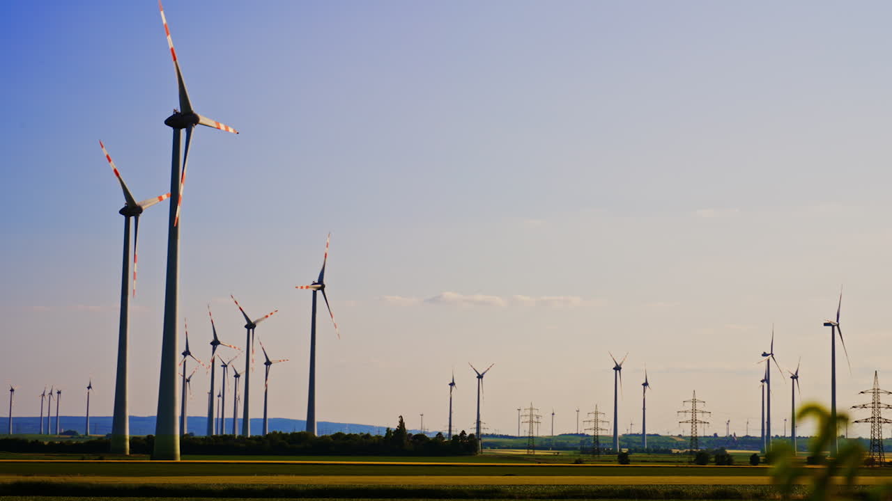 Wind turbines in rural area. Wind turbines stand tall in a rural setting, harnessing wind power under a clear blue sky during the day