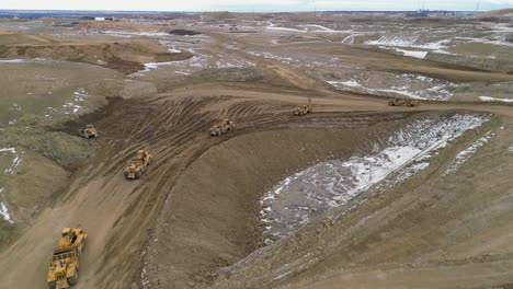 two wheel tractor scrappers are levelling the ground of a future site for housing