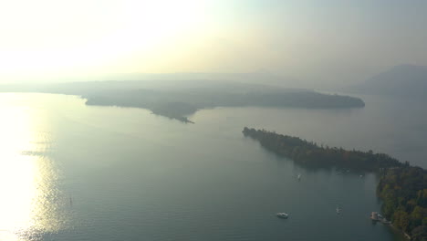 Volar-Sobre-La-Majestuosa,-Verde,-Isola-Del-Garda-En-La-Dura-Luz-Del-Atardecer