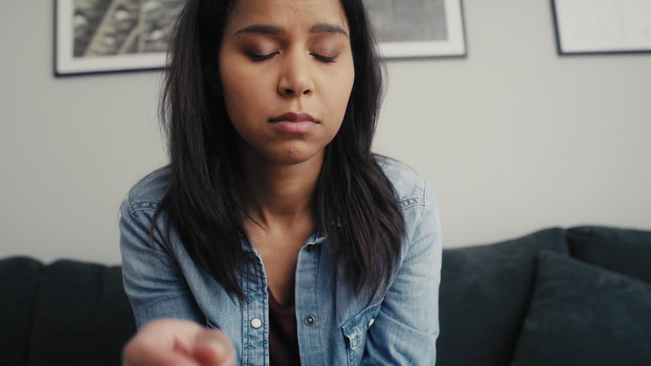 Tilt up video of broken mixed race woman holding an ultrasound scan and feeling negative emotions.