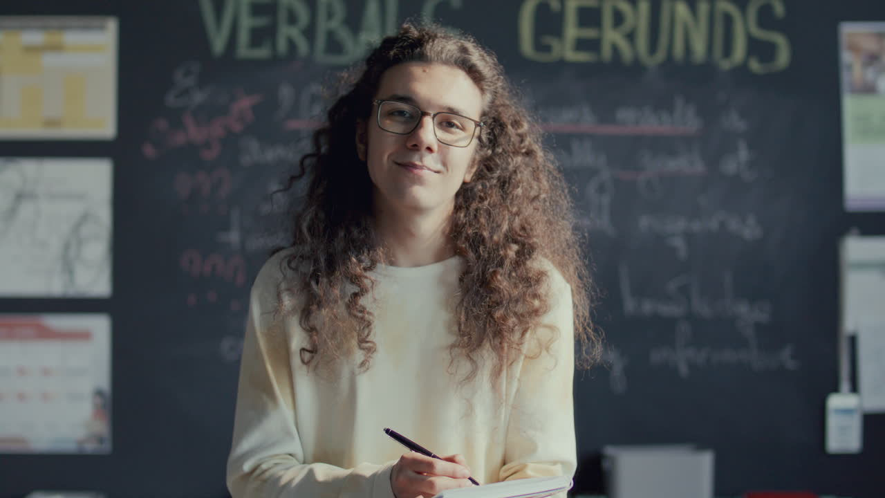 retrato de un joven estudiante escribiendo en un cuaderno en una clase universitaria