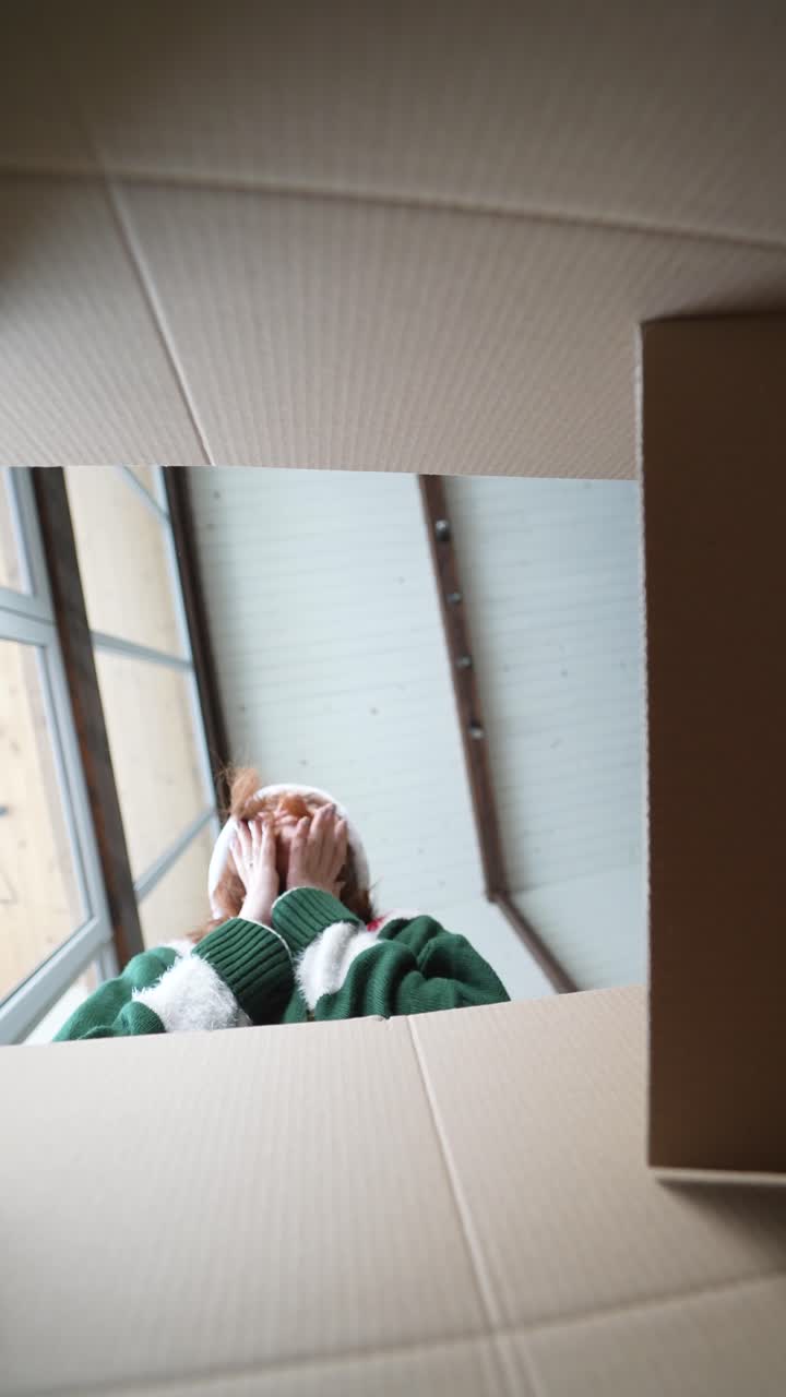 mujer emocionada abriendo el regalo de navidad