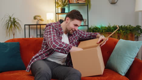 Zufriedener-Kunde-Mann-Auspacken-Lieferung-Paket-Kaufen-Online-Shop-Per-Postversand-Kurier