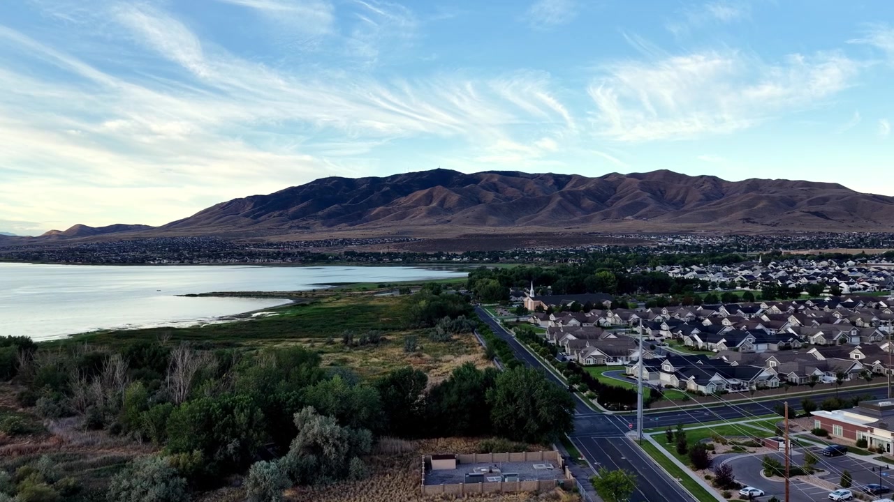 Saratoga Springs, Utah all'alba, che ritrae quartieri sereni, la riva del Lago Utah, panorami montani, cieli suggestivi e la luce dorata del mattino