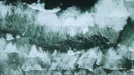 Overhead-aerial-of-multiple-waves-crashing-on-a-beach