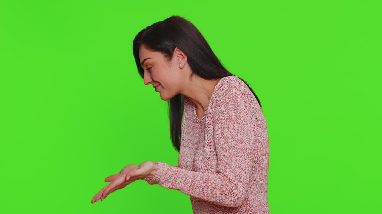 녹색 스크린에서 카메라를 향해 미소 짓고 손을 흔들고 있는 여자