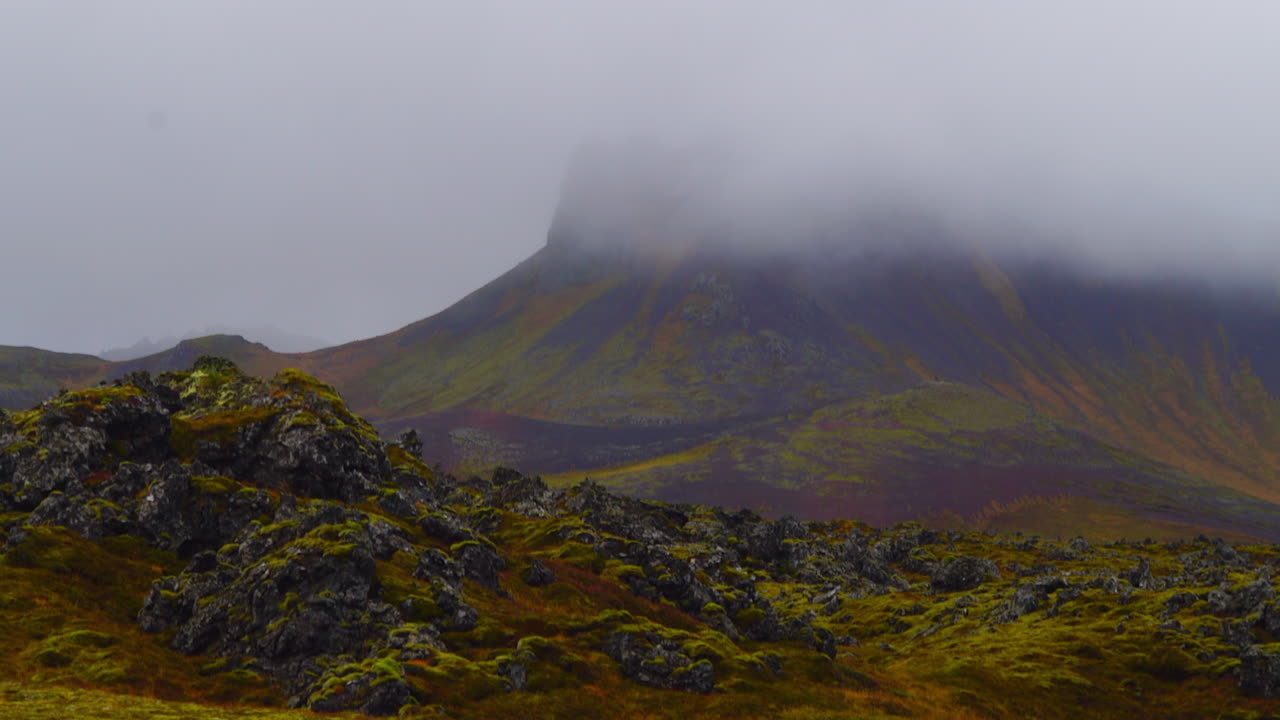 Djúpalónssandur Svarte Sandstrand Island, timelapse mot fjellandskap med tåke og skyer som driver forbi.