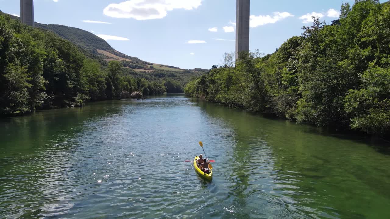 Vista aerea di persone che remano in kayak/canoa lungo il fiume verde e si divertono. Gruppo di giovani amici attivi che remano in canoa lungo la splendida valle del fiume verde a Millau, Francia.