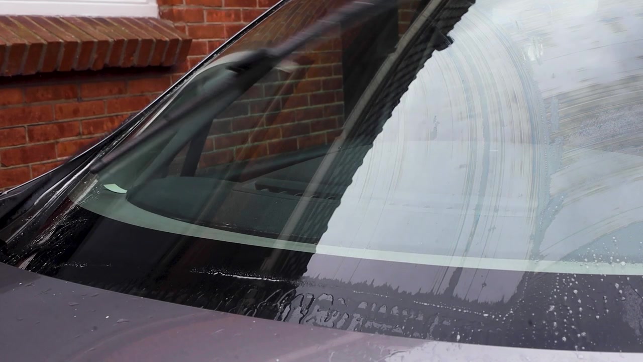 Video van ruitenwissers die de voorruit van een auto schoonmaken met ruitensproeiervloeistof