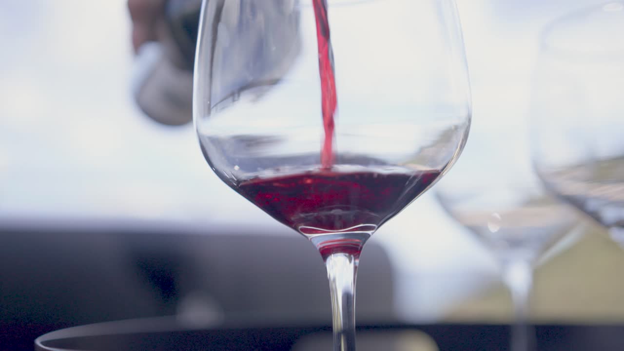 Versare il vino rosso in un bicchiere