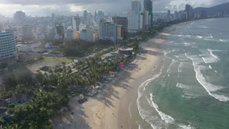 aerial view of long white sand stretch my khe, my bac an and non nuoc beach with huge waves in danang, central vietnam