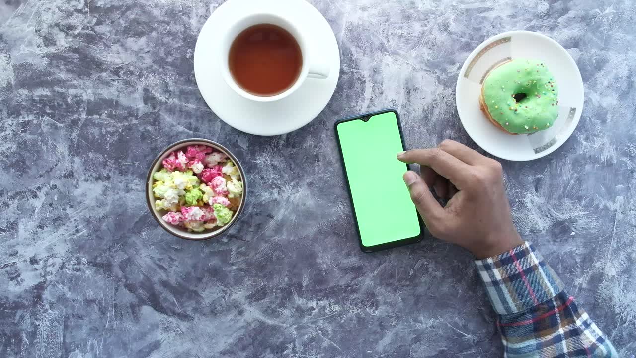 persona tomando un bocadillo y usando un teléfono