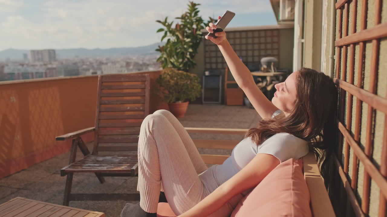 mujer relajándose en el balcón con vista a la ciudad