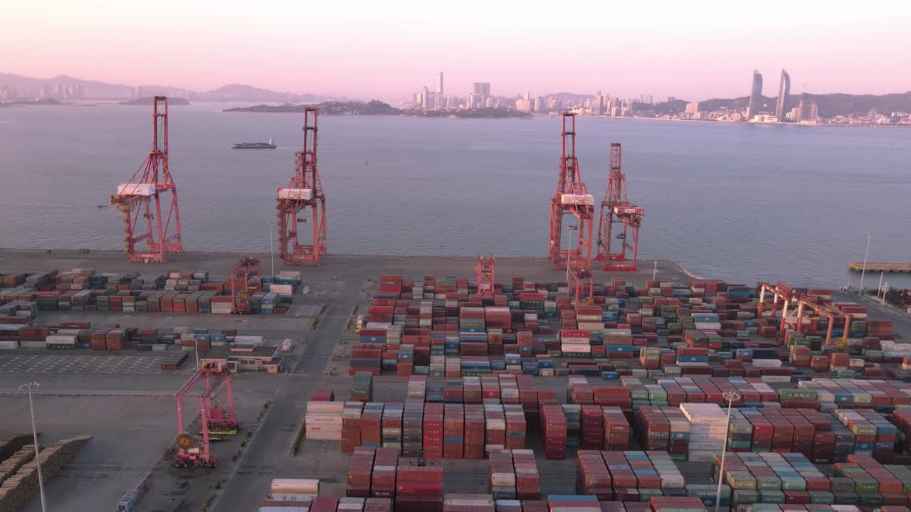 video aéreo de grúas y contenedores en el muelle al anochecer