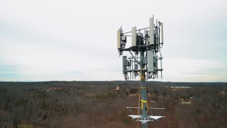 aerial shot flying toward cell phone tower in forest