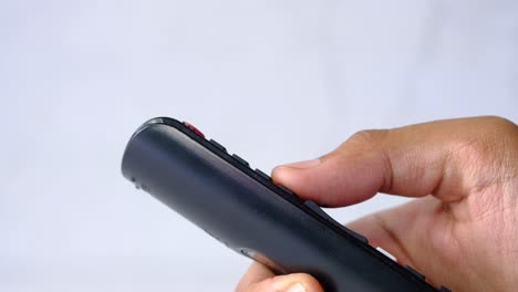 person holding a black tv remote control