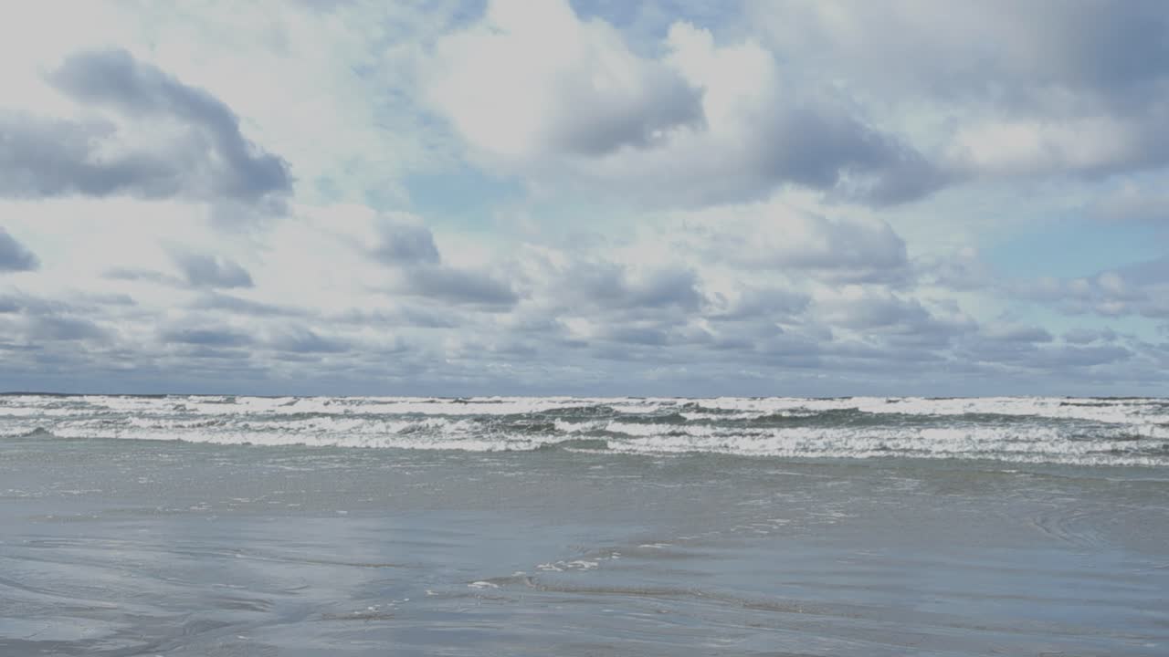 색 은 바다 바물 파도가 거품과 스플래싱과 함께 모래 노란색과 갈색 해변 해안선에 오는 화려한 낮은 각도 느린 동작 영상.