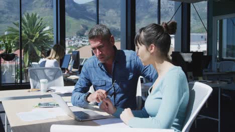 man and young woman working on computer