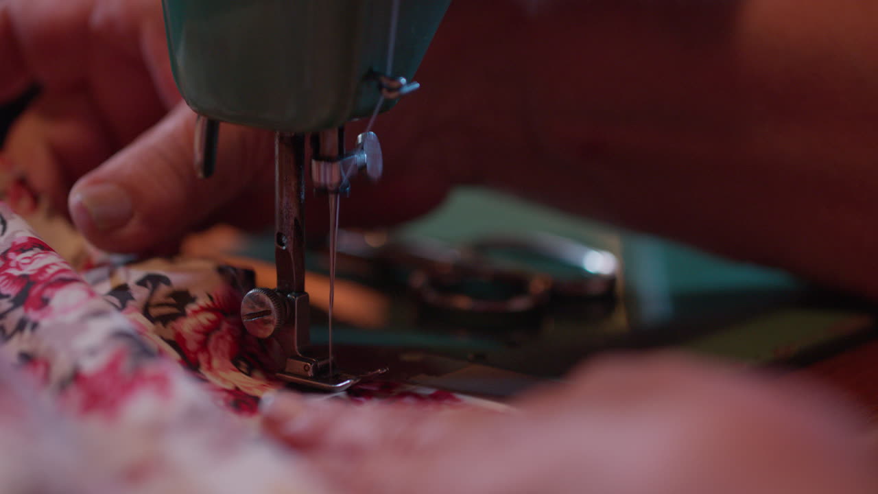 Close-up of Hands Sewing Floral Fabric on a Vintage Machine