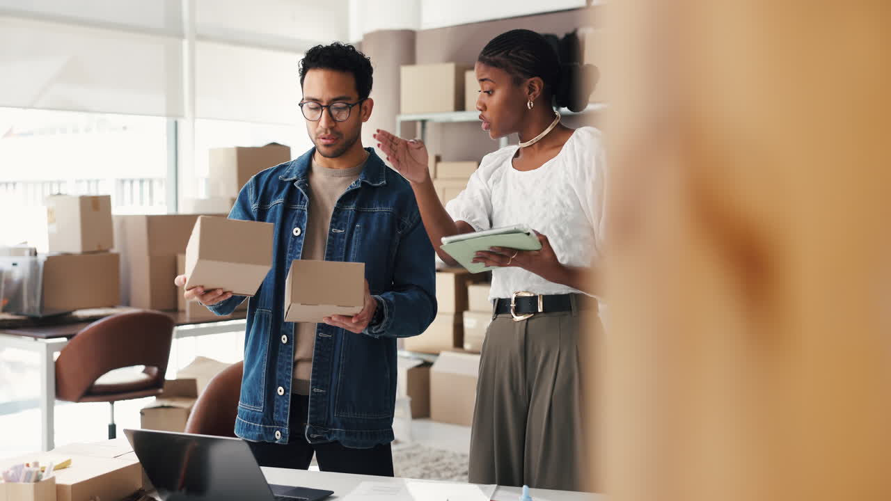 Partenaires commerciaux diversifiés vérifiant des cartons d'inventaire dans un bureau d'entrepôt