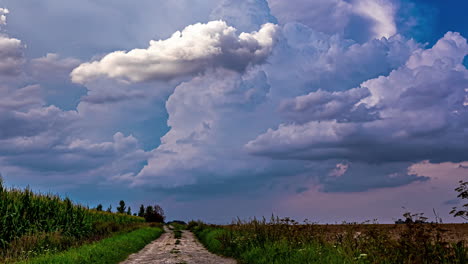 cumulus cloudscape moving over country road during stormy day