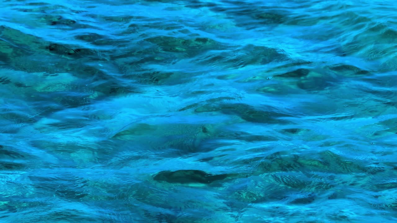 Close-up view of dynamic blue water ripples creating mesmerizing patterns and textures.