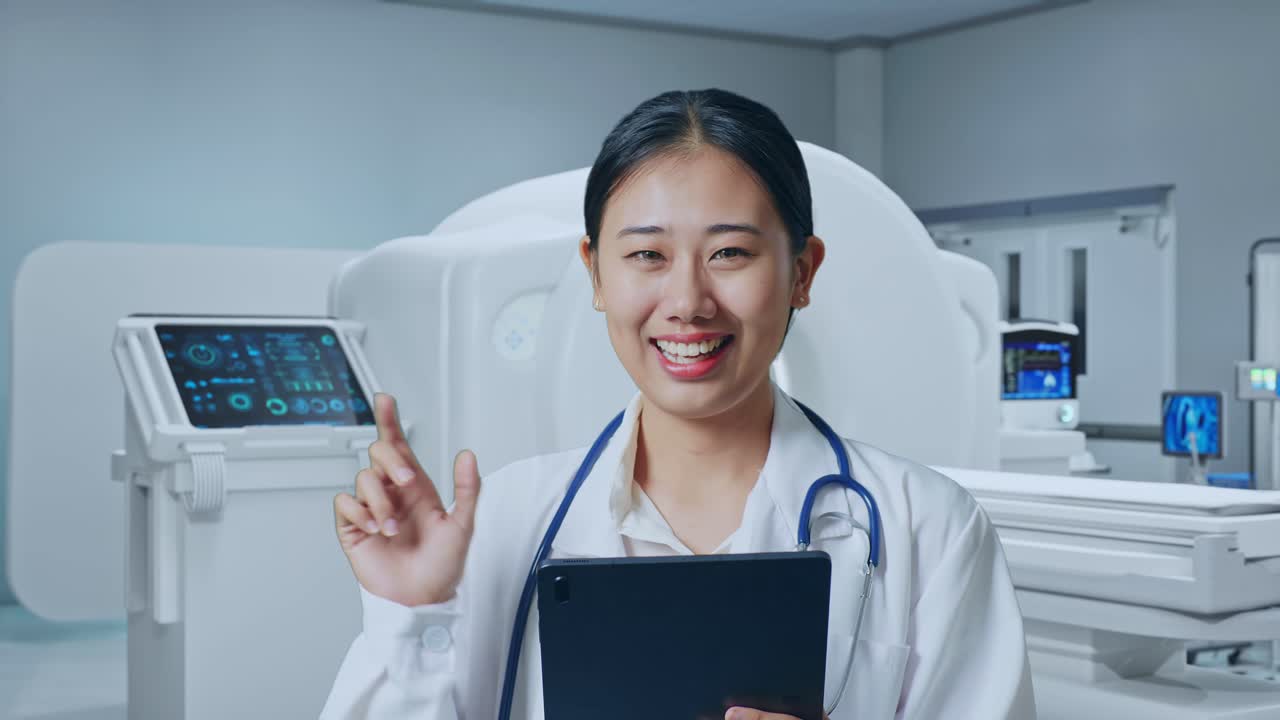 Close Up Of Asian Woman Doctor With Stethoscope Holding A Tablet And Pointing To Side While Standing With Mri Machine In The Hospital