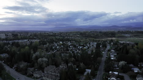 Purple-skies-and-clouds-over-small-city-filled-with-houses-and-roads-and-buildings