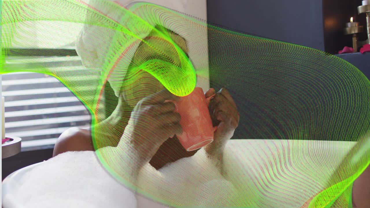 Woman reclining in tub foam, lifting pink mug, sipping self-care while green wave overlay drifting